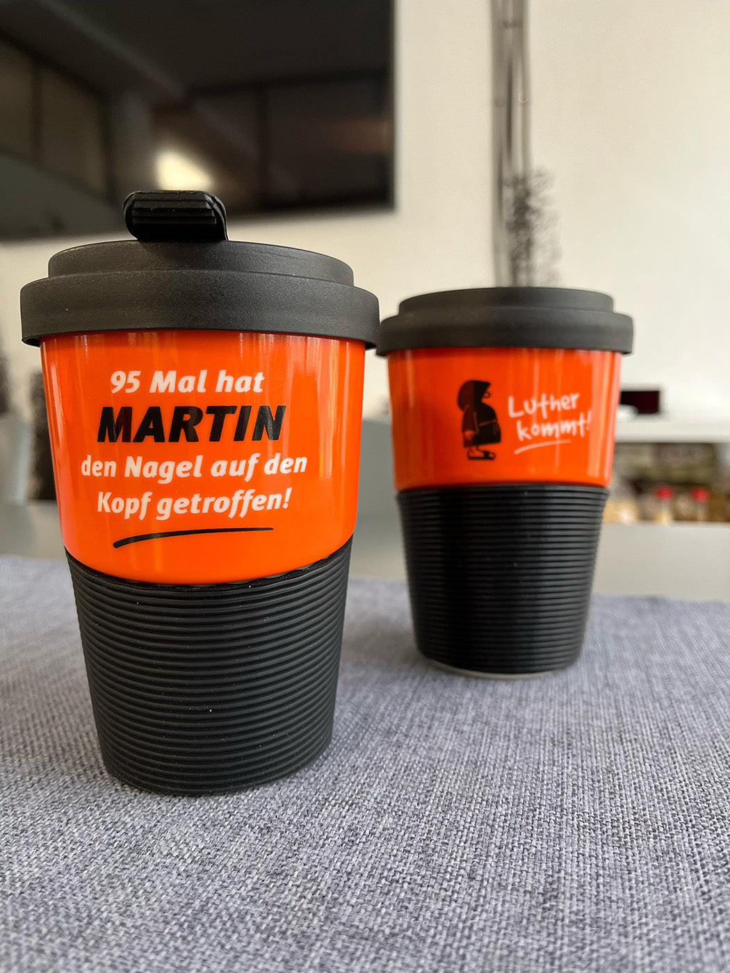 Kaffeebecher aus Porzellan in Orange mit dem Text "95 Mal hat Martin den Nagel auf den Kopf getroffen"