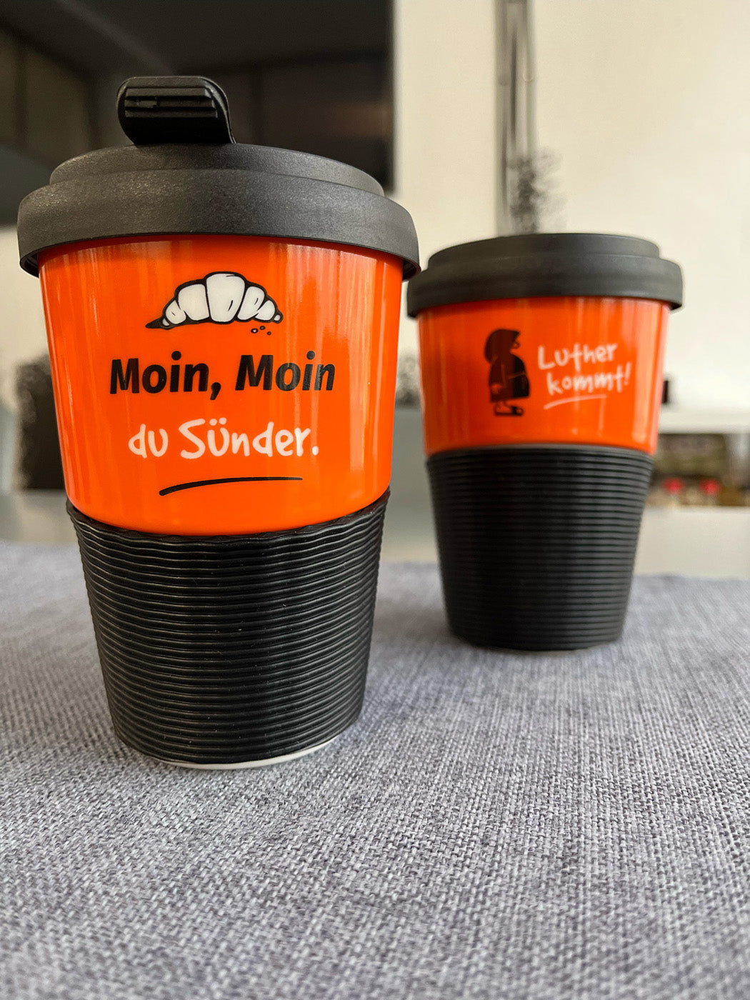Kaffeebecher aus Porzellan in Orange mit dem Text "Moin, moin, du Sünder"