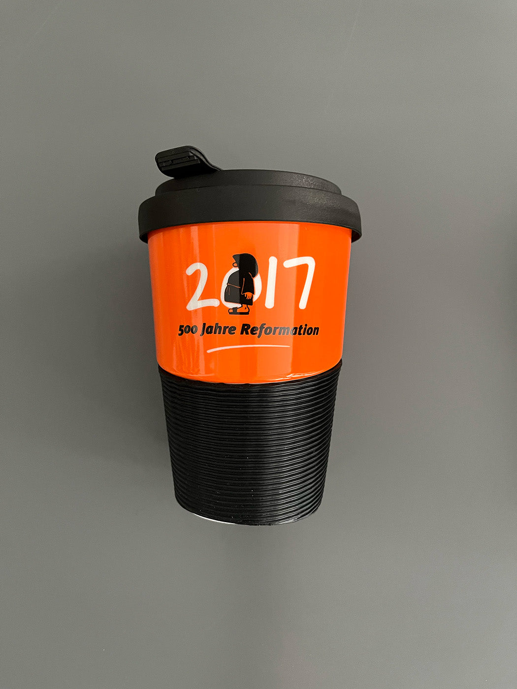 Kaffeebecher aus Porzellan in Orange mit dem Text "2017 - 500 Jahre Reformation"