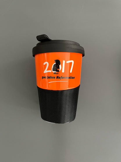 Kaffeebecher aus Porzellan in Orange mit dem Text "2017 - 500 Jahre Reformation"