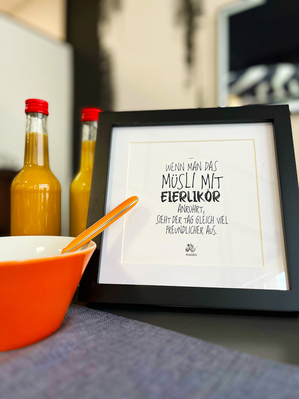 Weißes Bild von #heinzigartig mit Rahmen und dem Text "Wenn man das Müsli mit Eierlikör anrührt, sieht der Tag gleich viel freundlicher aus."