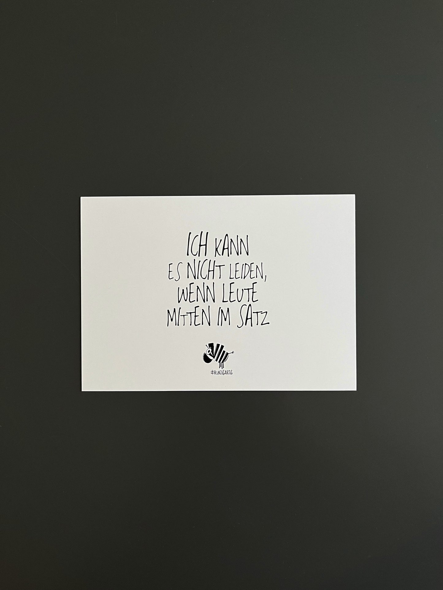 Weiße Postkarte von #heinzigartig mit dem Spruch: "Ich kann es nicht leiden, wenn Leute mitten im Satz"