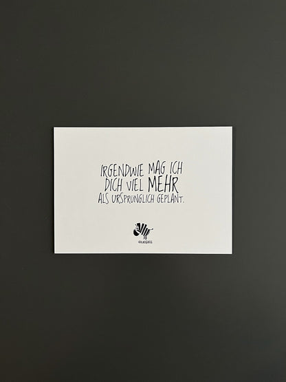 Weiße Postkarte von #heinzigartig mit dem Spruch: "Irgendwie mag ich dich viel mehr, als ursprünglich geplant"