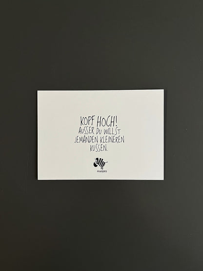 Weiße Postkarte von #heinzigartig mit dem Spruch: "Kopf hoch! Ausser du willst jemanden kleineren küssen."