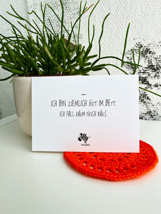 Weiße Postkarte von #heinzigartig mit dem Spruch: "Ich bin ziemlich gut im Bett. Ich fall kaum noch raus."