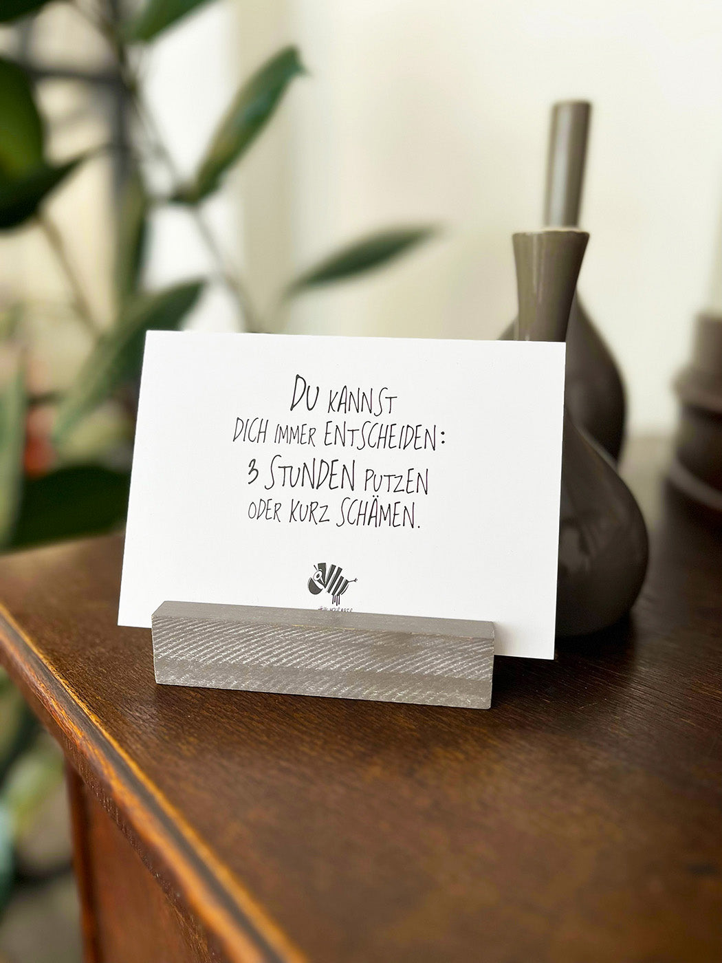 Weiße Postkarte von #heinzigartig mit dem Spruch: "Du kannst dich immer entscheiden: 3 Stunden putzen oder kurz schämen."