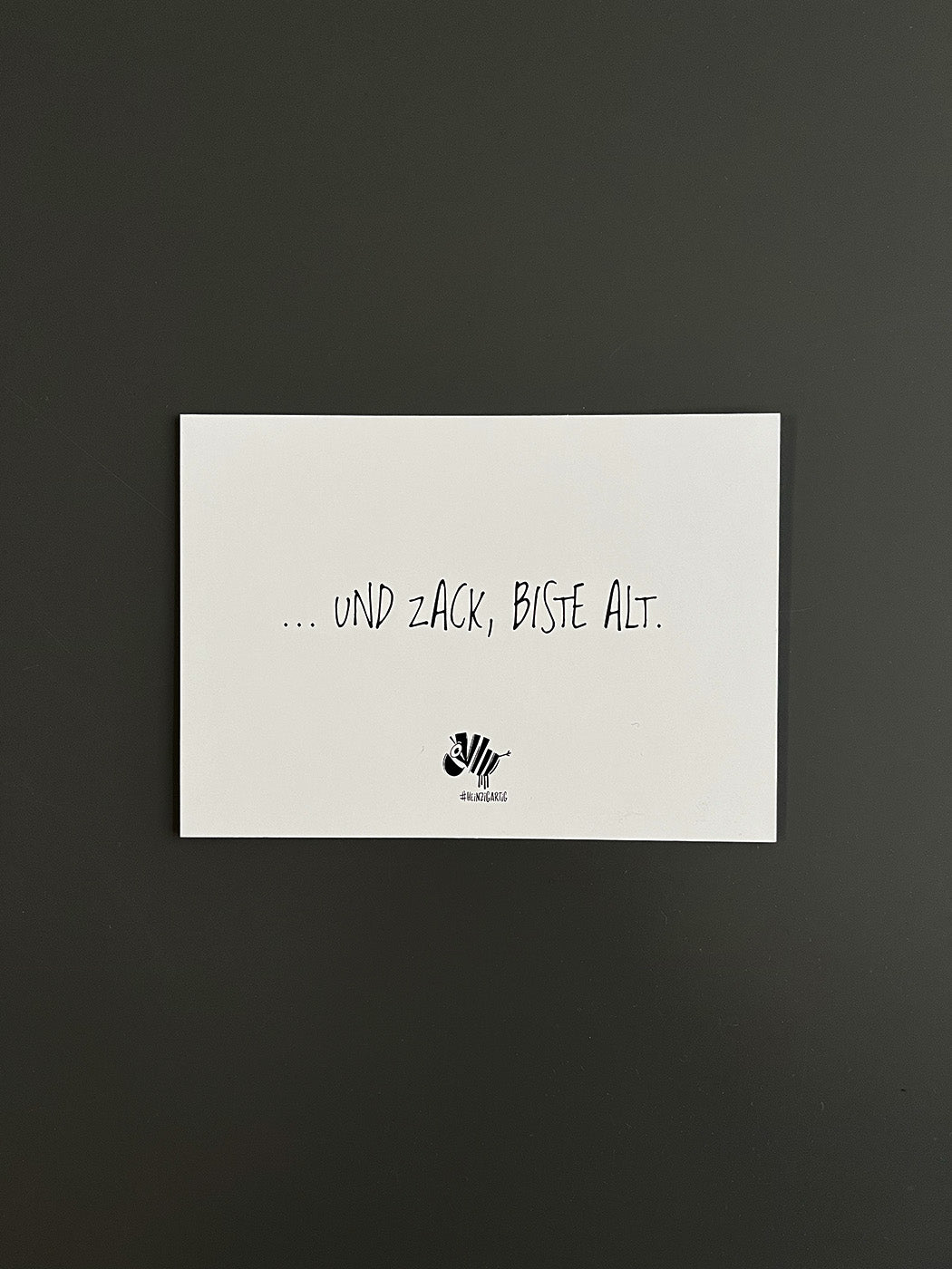 Weiße Postkarte von #heinzigartig mit dem Spruch: "... und zack, biste alt"