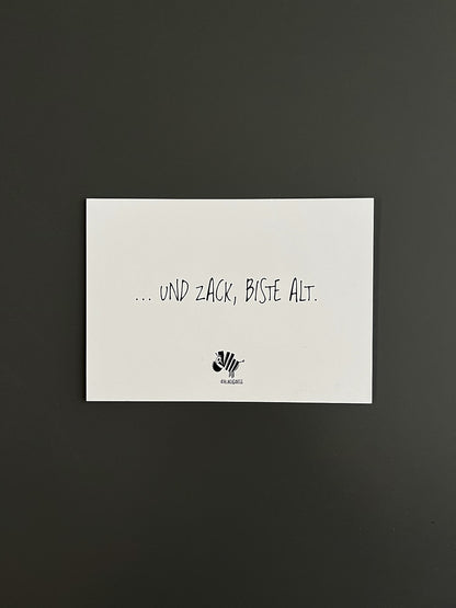 Weiße Postkarte von #heinzigartig mit dem Spruch: "... und zack, biste alt"